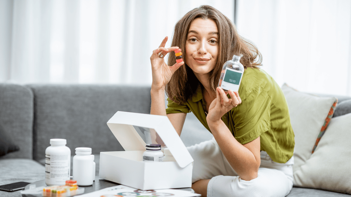Młoda kobieta trzyma w dłoniach suplementy diety (fot. shutterstock.com)