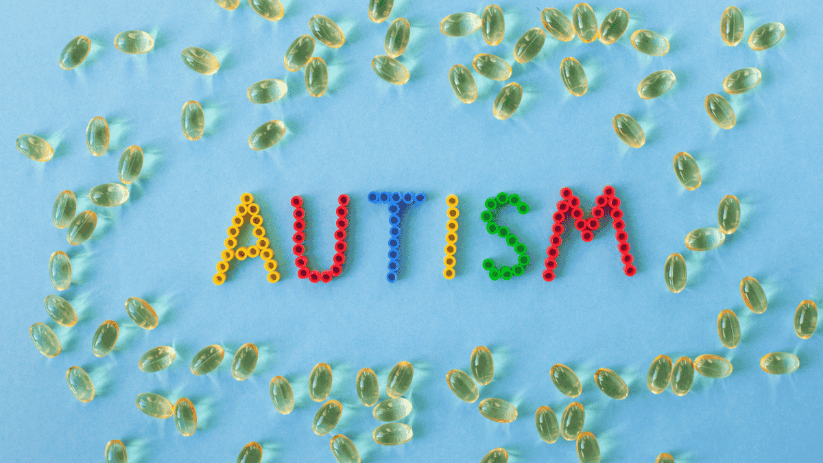 Napis AUTISM na tle żółtych kapsułek (fot. iStock)