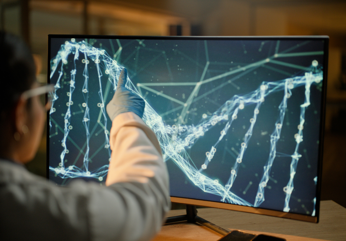 Naukowiec pokazuje na ekranie nić DNA i gen