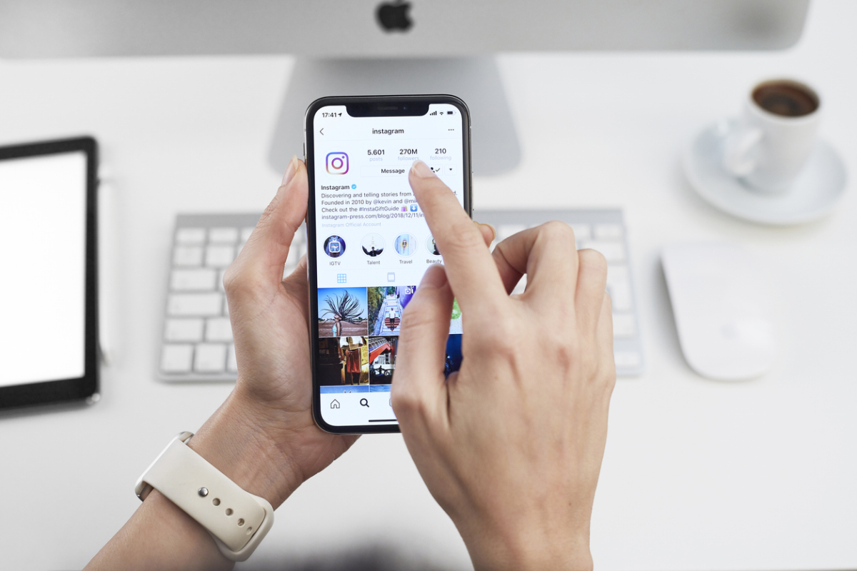 Kobieta trzyma w dłoniach telefon z instagramem na ekranie