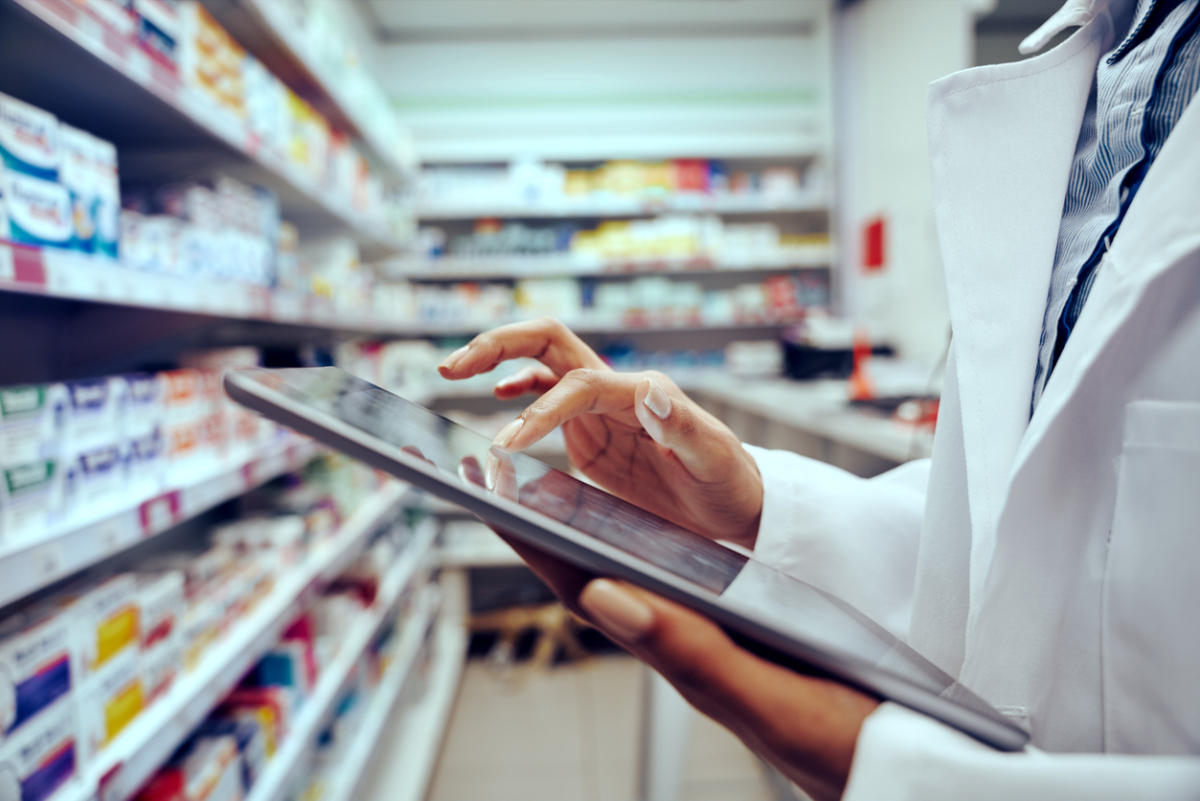 Farmaceutka trzyma tablet w magazynie z lekami w aptece