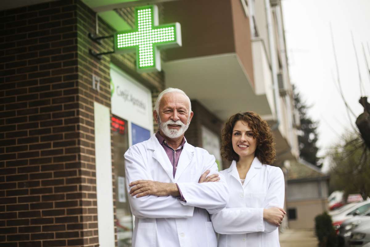 farmaceuta i farmaceutka pod apteką