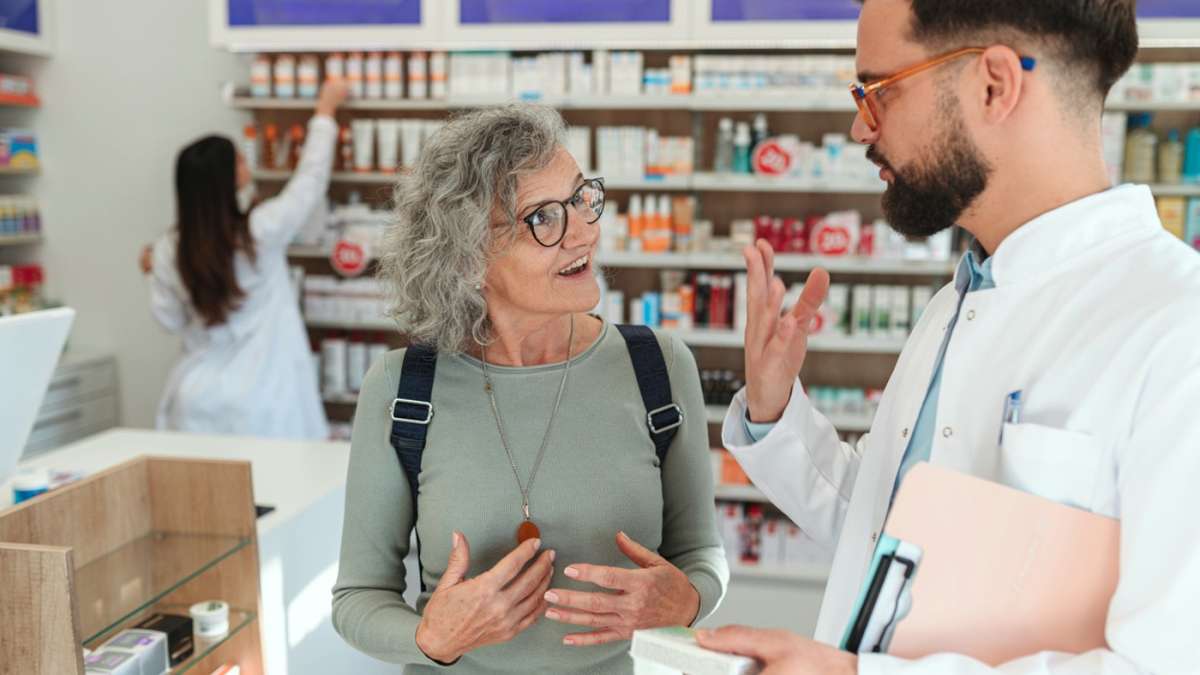 farmaceuta rozmawia ze starszą wysportowaną kobietą