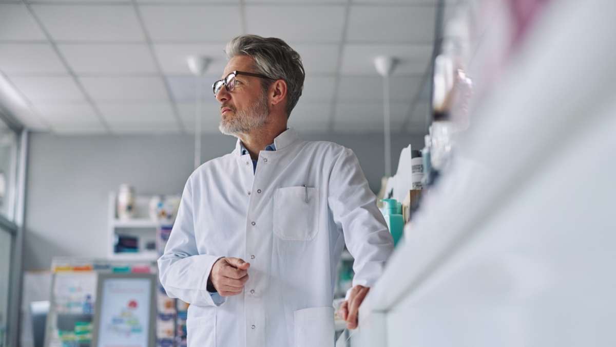 Zamyślony farmaceuta w aptece