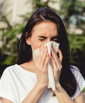 Młoda kobieta w praku ma kaszel i alergię (fot. istockphoto.com)