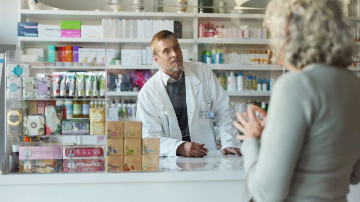 Farmaceuta w okienku rozmawia z pacjentką