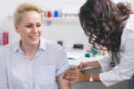 Szczepienie w aptece pacjentka otrzymuje szczepionkę od farmaceutki