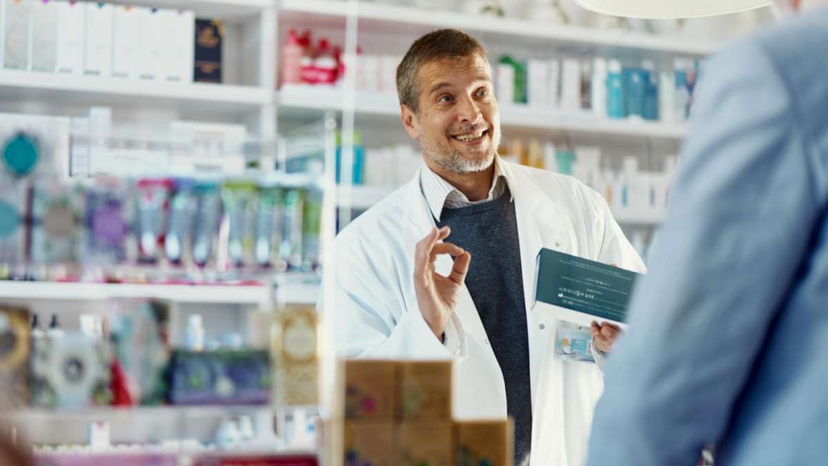 farmaceuta zachwala lek w rozmowie z pacjentem w aptece