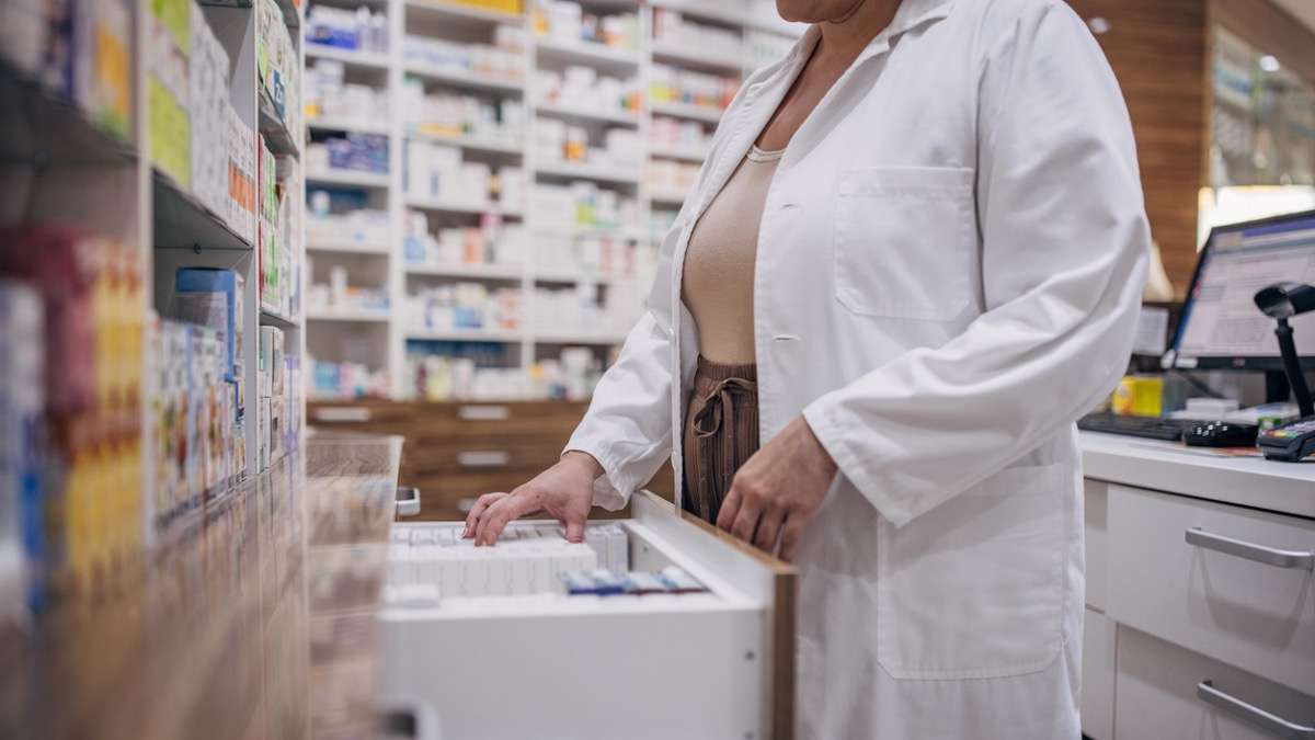 farmaceutka szuka leku w szufladzie w aptece